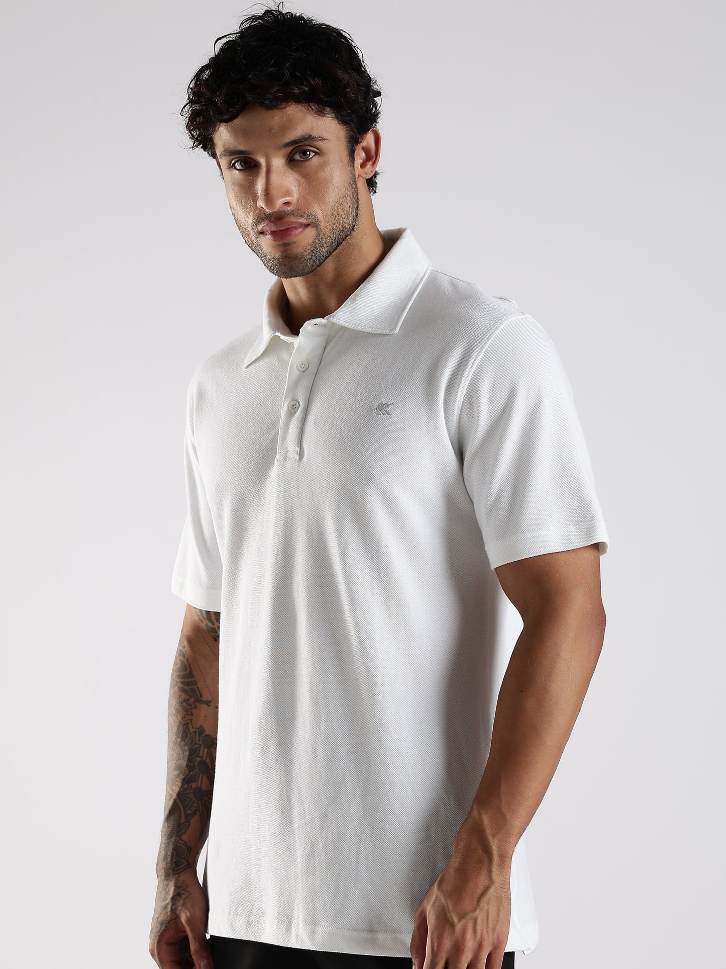 Man wearing a premium white polo shirt against a plain background