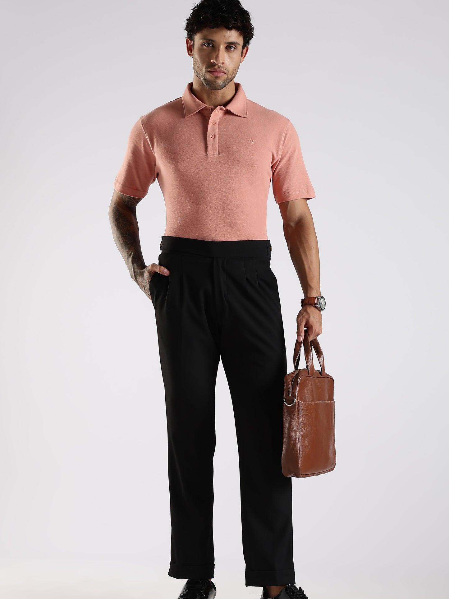 Model styling a peach plain cotton polo shirt, featuring a structured fused collar that elevates the classic polo design.