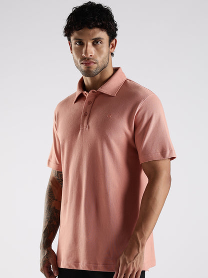 Side profile of a male model wearing a peach cotton polo, showcasing its tailored shirt-style collar with stand.