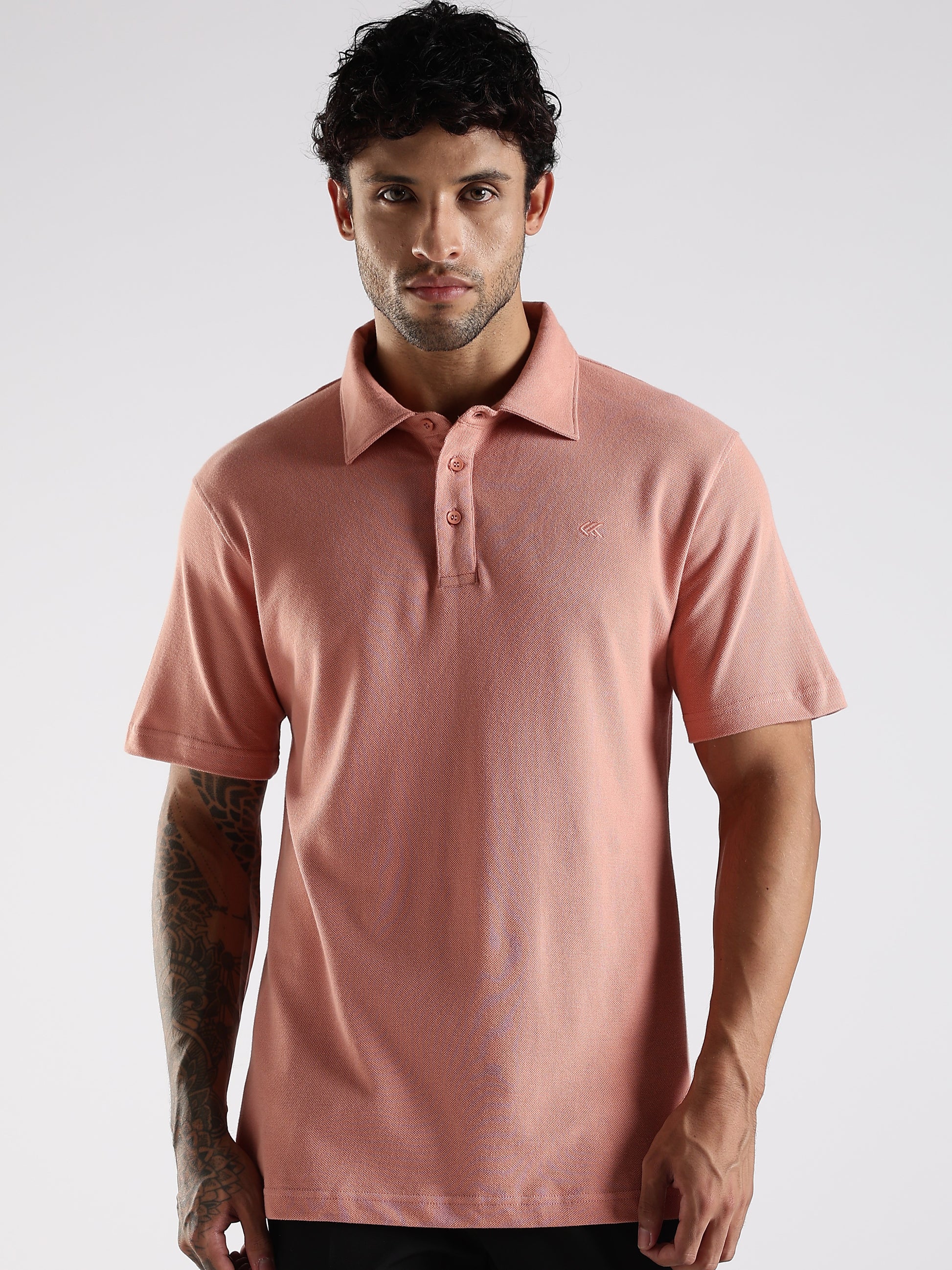 Man wearing a pink polo shirt against a white background